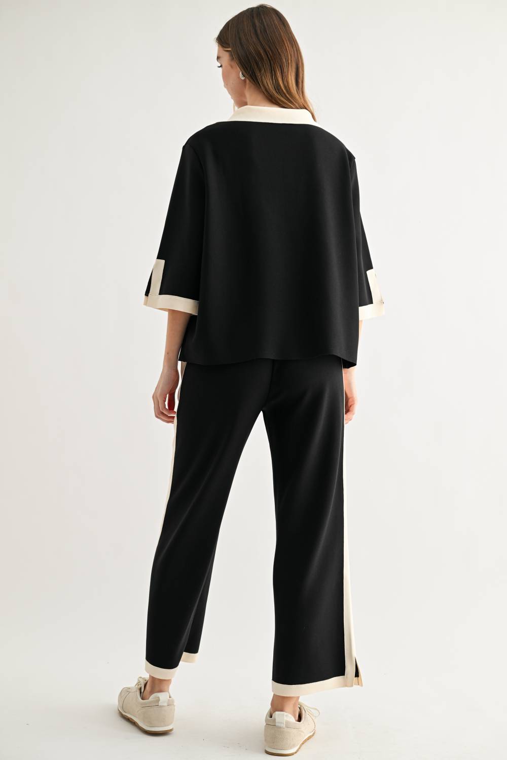 Back view of Kristopher black wide-leg pants with cream contrast stripe